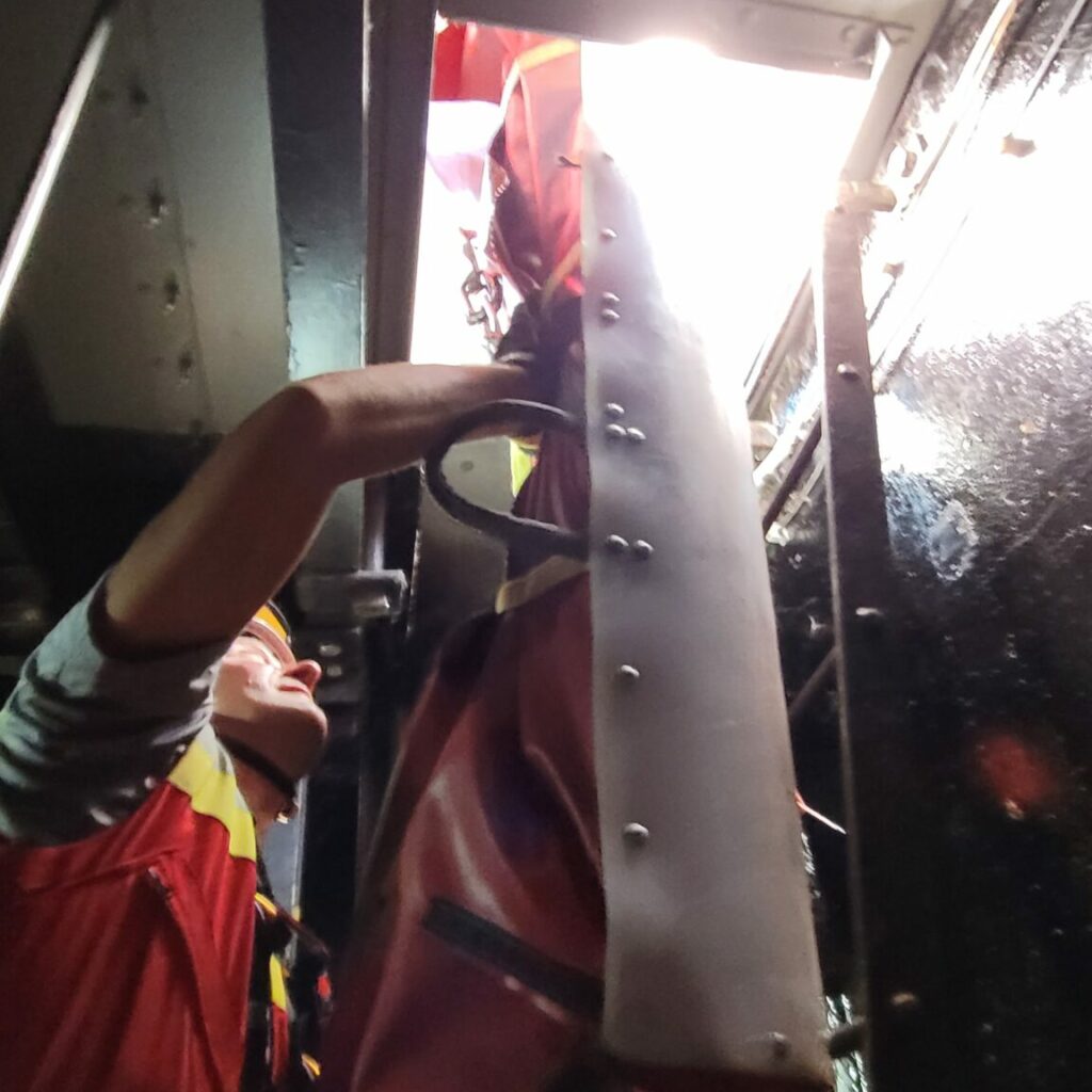 Ratownik z noszami Ratownik trzyma nosze w przestrzeni zamkniętej